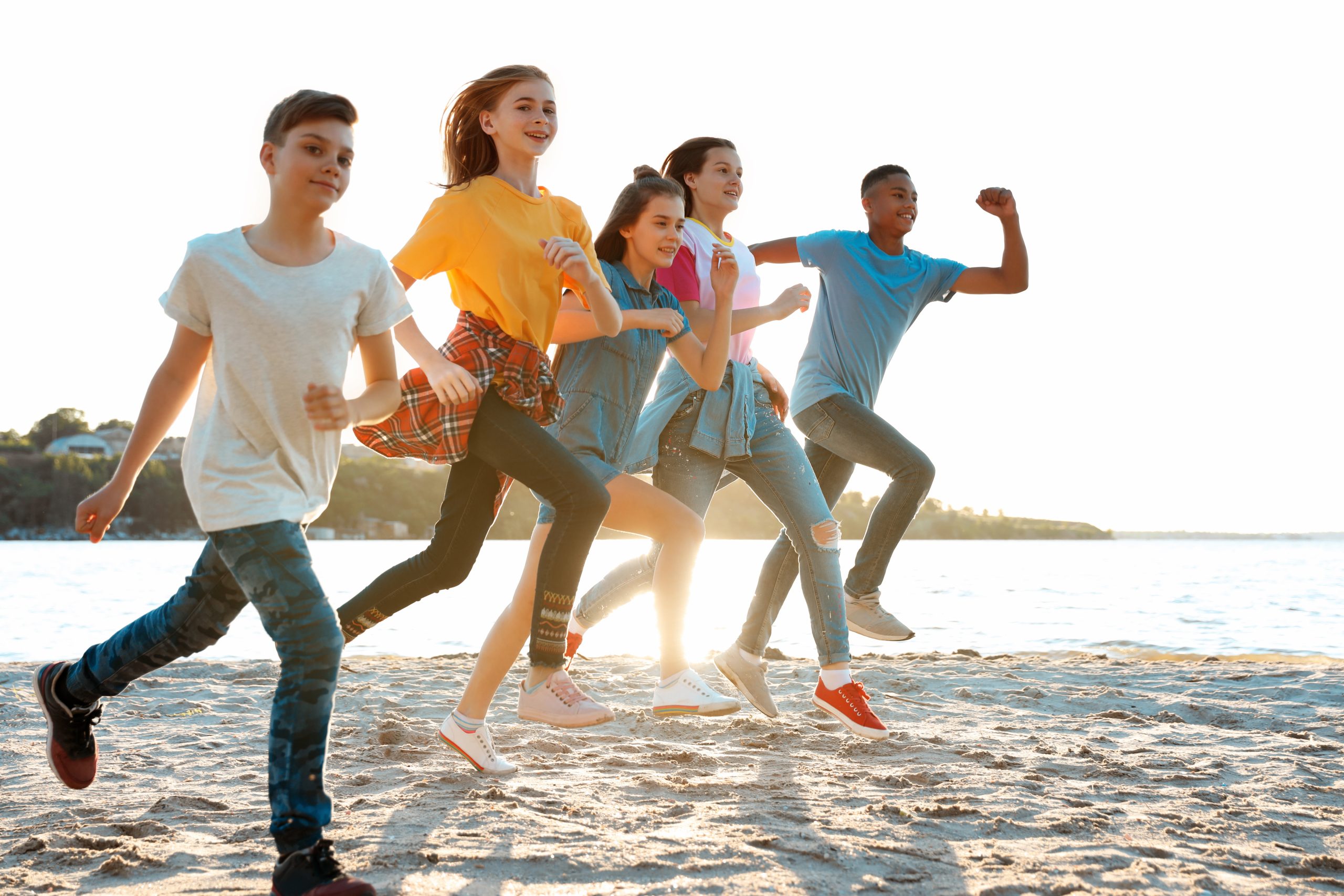 Group of children running on beach. Summer camp kids running on the beach